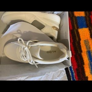 Platform running shoe, all white with a mesh insole and gold detail.